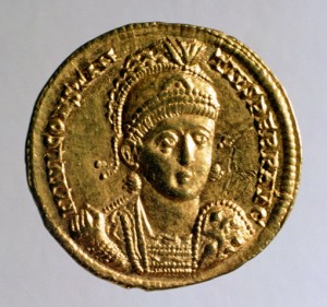 Gold solidus of Constantius II, with the bust of the emperor wearing military dress and helmet, with a spear and shield. 351–355 CE.