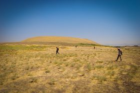 (Fig. 3) Part of the LoNAP team performing artefacts collection in the lower town of a large site (background) not far from the modern city of Duhok.